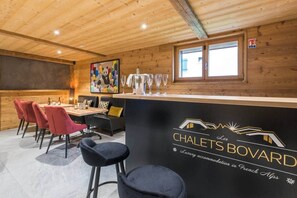 A cozy interior with a bar area, seating, and a painting on the wall.
