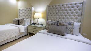 Une chambre d’hôtel avec deux lits, une table de chevet, une lampe et un miroir.