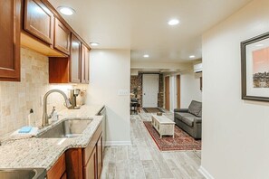 A modern kitchen with granite countertops, wooden cabinets, and a built-in sink.