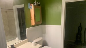 A bathroom with a sink, toilet, and mirror. There is a towel rack above the mirror and a shower curtain rod visible. - Cozy Studio apartment with cabin feel (Tallahassee)