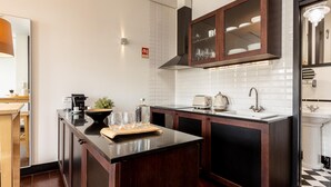 A modern kitchen with dark wood cabinets, a black countertop, and a white tiled backsplash. - Torre 1 in Oporto With 1 Bathrooms (Porto)