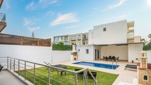 A modern residential building with a swimming pool, outdoor seating, and a small garden area. - Villa Cataleya : A Spacious, Private Oasis with a Pool Near the Beach (Chania)