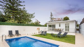 A swimming pool with lounge chairs and a small garden area. - Villa Cataleya : A Spacious, Private Oasis with a Pool Near the Beach (Chania)
