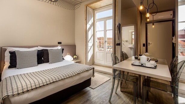 A bedroom with a bed, bedside table, and a view of the outside. - Cl Rigos 2B in Porto (Porto)