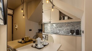 A modern kitchen with a marble countertop, a dining area with a tray of breakfast items, and pendant lighting. - Cl Rigos 2B in Porto (Porto)
