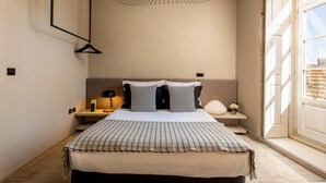 A bedroom with a bed, bedside tables, a hanging light fixture, and a window with a view. - Cl Rigos 2B in Porto (Porto)