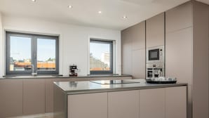 A modern kitchen with two large windows, a built-in oven, and a coffee machine. - RA - Santa Catarina in Oporto (Porto)
