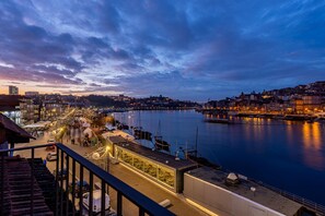 A waterfront cityscape at dusk with buildings, a marina, and a pedestrian walkway. - Ribeira Gaia 3 in Vila Nova de Gaia (Vila Nova de Gaia)