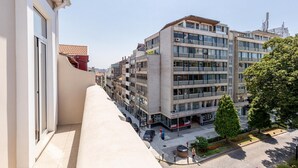 A modern apartment building with multiple balconies, a paved street, and a clear sky. - Cosy 5 in Oporto With 1 Bedrooms and 1 Bathrooms (Porto)