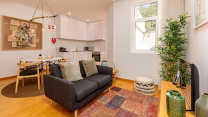 Een moderne woonkamer met een bank, een eettafel en een keukenhoek.