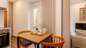 A compact kitchen with a wooden table, two chairs, a coffee maker, and a tray. - Cosy 0 in Oporto With 1 Bathrooms (Porto)