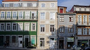 A row of multi-story buildings with various storefronts, including a pharmacy and a water supply company. - Cosy 0 in Oporto With 1 Bathrooms (Porto)