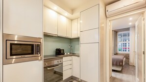 A compact kitchen with a built-in microwave, a coffee machine, and a small countertop. - Ribeira Porto 0 in Oporto (Porto)