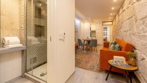 A modern interior with a shower, a dining area, and a living space with a sofa and a small table. - Ribeira Porto 0 in Oporto (Porto)