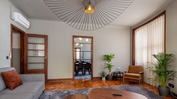 A modern living room with a grey sofa, a wooden coffee table, and a large mirror. - Santa Catarina 1D in Oporto (Porto)