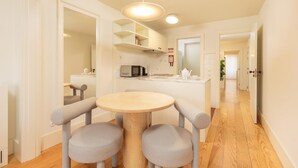 Una cocina moderna con una mesa redonda y sillas, un microondas y un lavamanos.