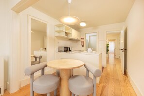 A modern kitchen with a round table and chairs, a microwave, and a sink. - Flores S in Porto With 1 Bedrooms and 1 Bathrooms (Porto)