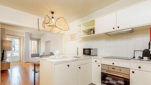A modern kitchen with white cabinetry, a built-in oven, and a microwave. - Flores M in Porto With 1 Bedrooms and 1 Bathrooms (Porto)