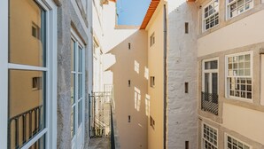 A narrow alleyway between buildings with balconies and windows. - Flores M in Porto With 1 Bedrooms and 1 Bathrooms (Porto)