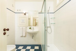 A bathroom with a checkered floor, a sink, a mirror, and a shower. - Flores G in Porto With 1 Bedrooms and 1 Bathrooms (Porto)