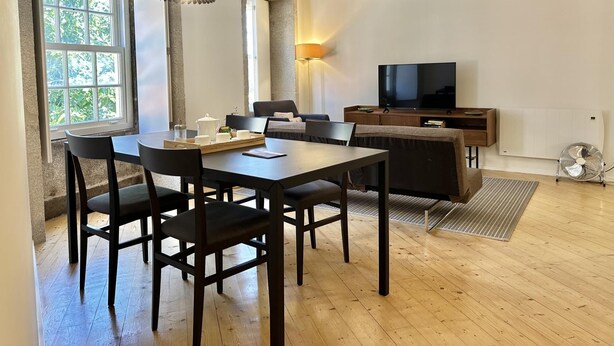 Una sala de estar moderna con comedor, televisor y radiador.