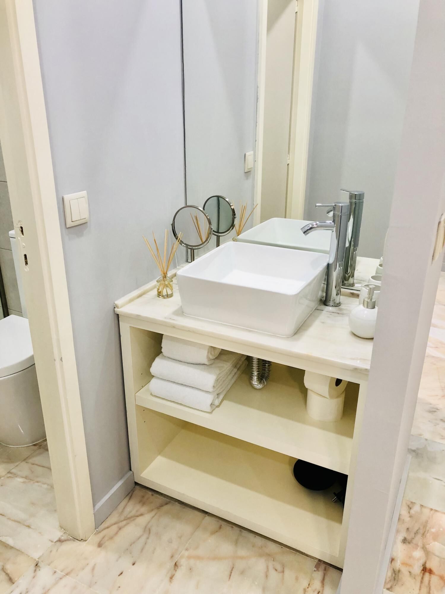 A bathroom with a white sink, a mirror, and a towel rack.