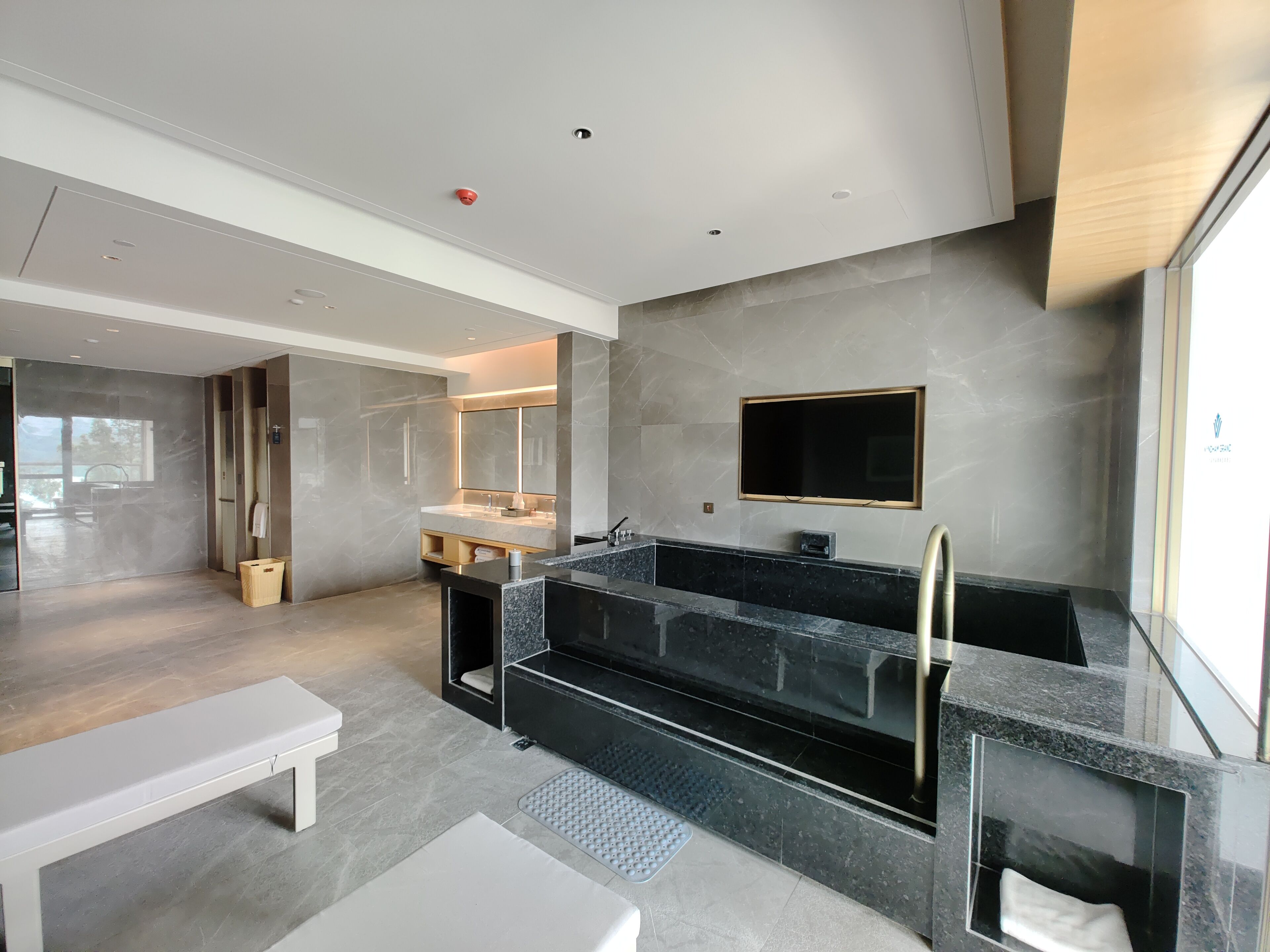 Une salle de bain moderne avec une grande baignoire, un meuble-lavabo avec un miroir et des toilettes.