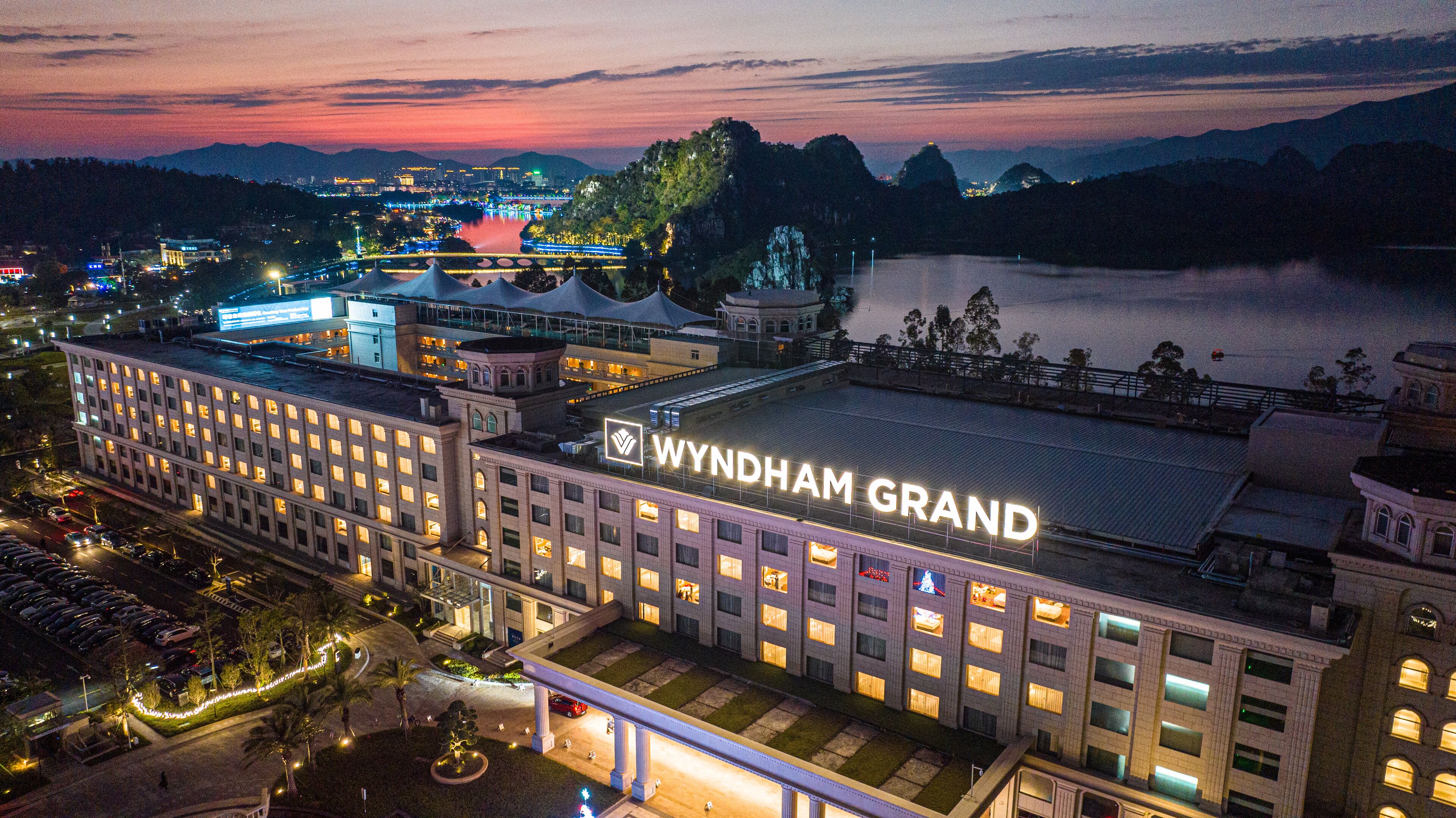 Suuri hotelli, jossa on selkeästi näkyvässä paikassa suuri «WYNDHAM GRAND» -kyltti, useita kerroksia ja pysäköintialue.
