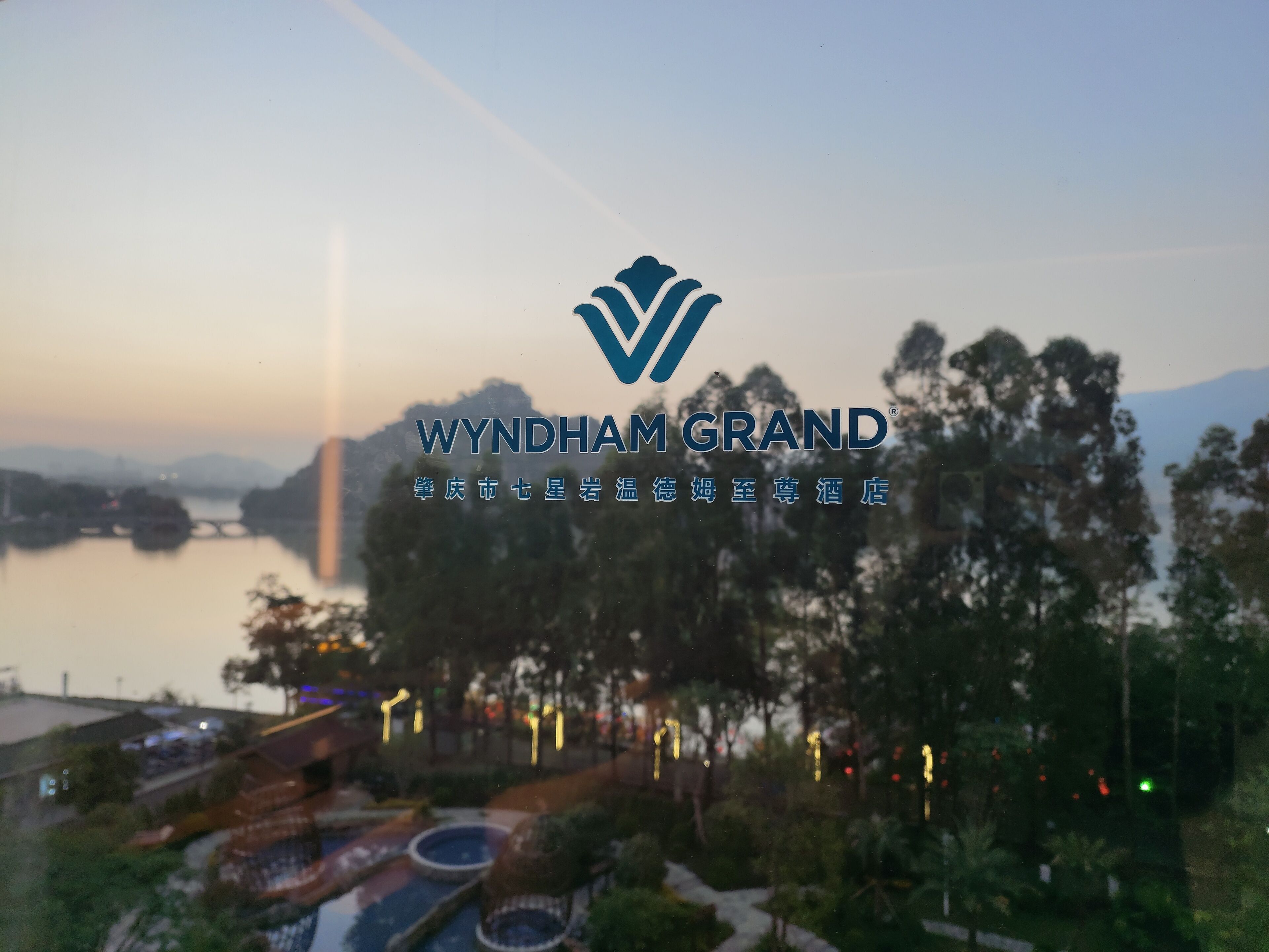 Ein Logo mit dem Text 'WYNDHAM GRAND' und chinesischen Schriftzeichen.