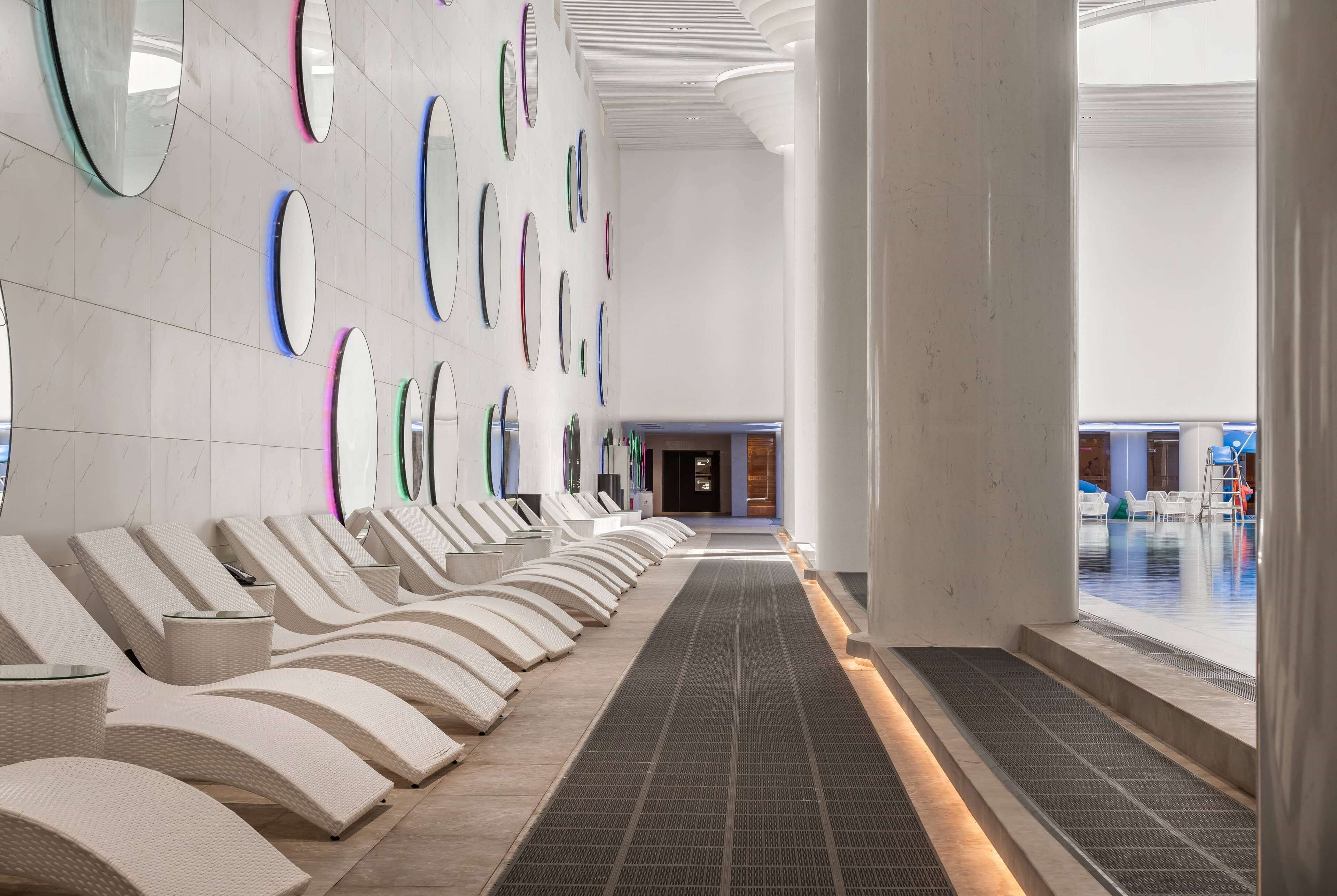 A modern lobby with a row of lounge chairs and a patterned floor leading to a reception area.