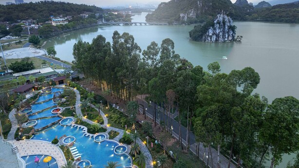 A resort with multiple swimming pools, a large body of water, and a bridge. - Wyndham Grand Zhaoqing Downtown (Zhaoqing)