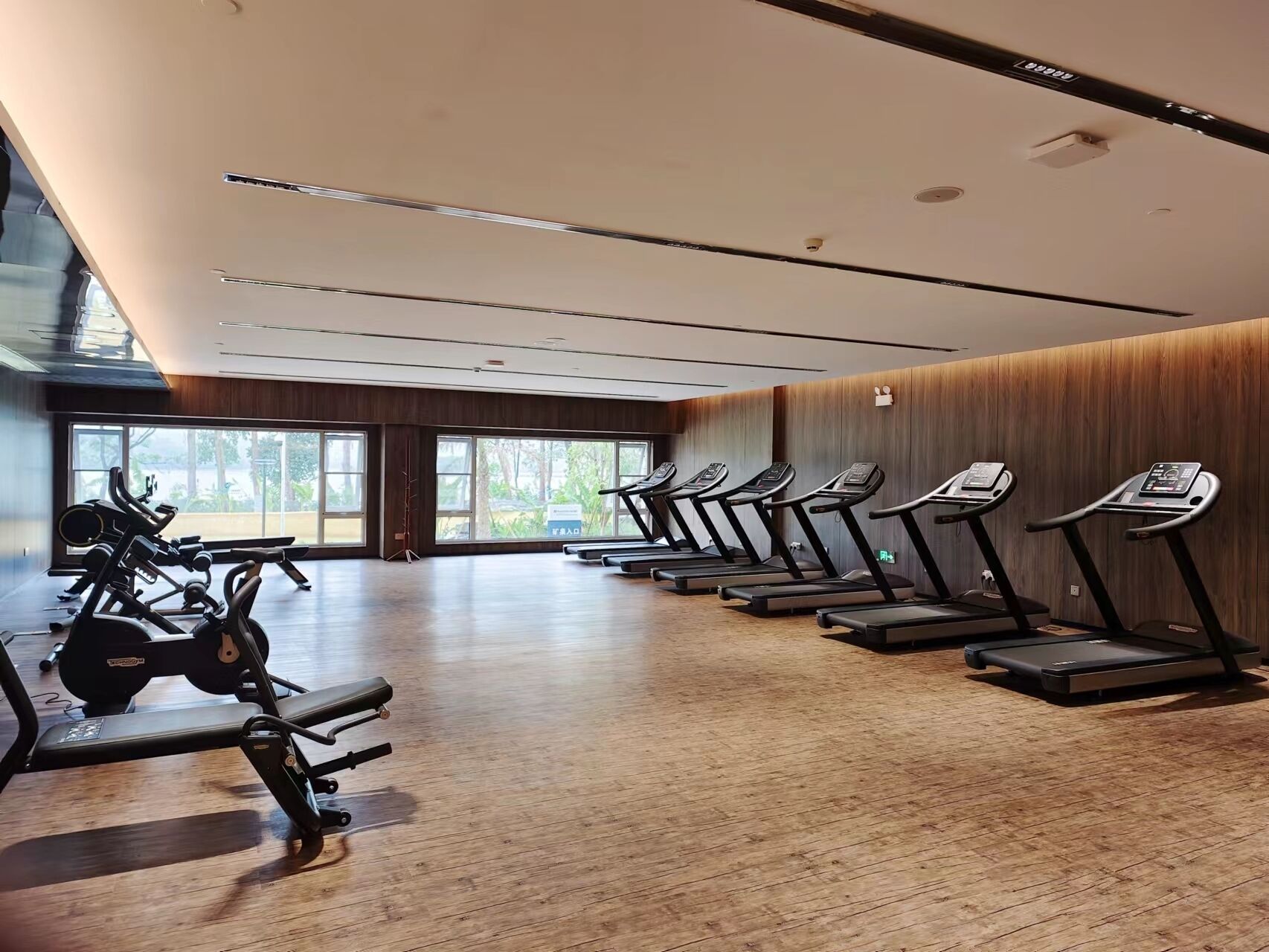 Un gimnasio con cintas de correr, bicicletas estáticas y máquinas de pesas.