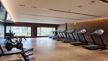 Un gimnasio con cintas de correr, bicicletas estáticas y máquinas de pesas.