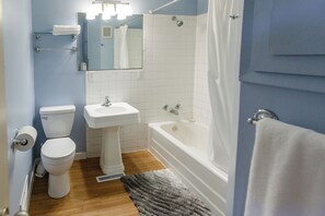 Une salle de bain comprenant des toilettes, un lavabo, une baignoire et une douche.