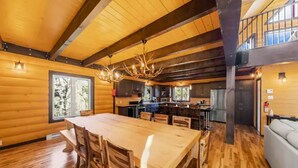 L’intérieur d’une cabane en rondins comprend un coin repas, une cuisine et une chambre à coucher située en mezzanine.