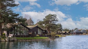 Un albergue junto al lago con una amplia terraza, un muelle para embarcaciones y vistas al lago.