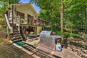 Ein Haus mit Terrasse, Grill und einer Treppe zu einer Außengaststätte.