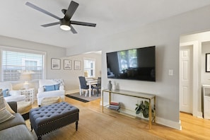 Relax in this stylish living room with a flat-screen TV, dining area, and comfortable seating.