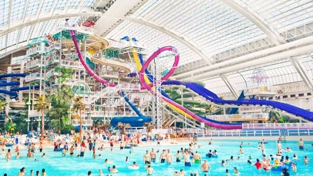 A large indoor water park with multiple water slides and pools.