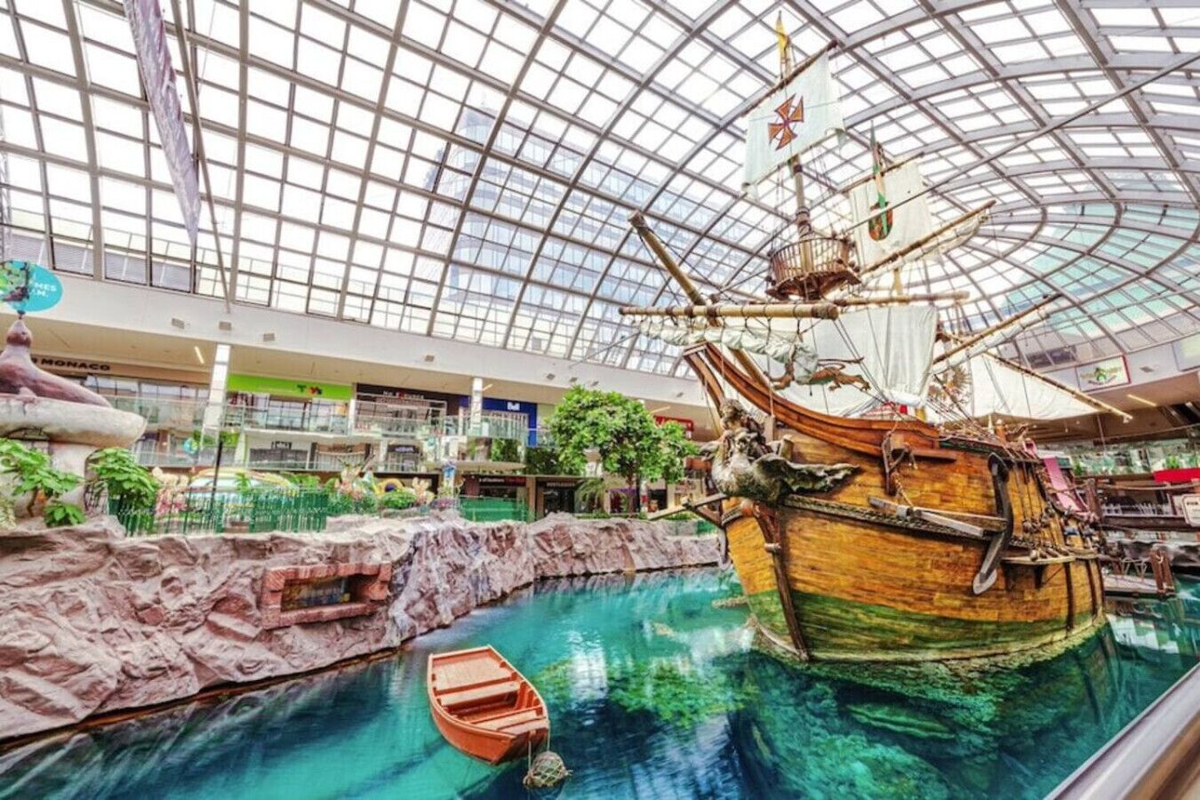 Een binnenaquarium met een groot schip en een klein bootje in een waterpartij.