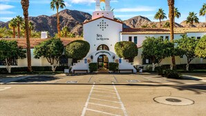 A building with a sign reading 'SPA LA QUINTA' and a parking lot in front. - SV112 Deluxe Spa Villa w/ Majestic Mountain Views (La Quinta)