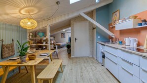 Una cocina acogedora con encimeras de madera, un rincón de comedor con un banco y una escalera que sube a otra habitación.