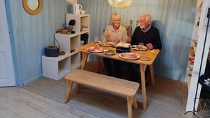 Un comedor acogedor con una mesa de madera dispuesta para dos personas, rodeado de paredes azul claro y un techo blanco.