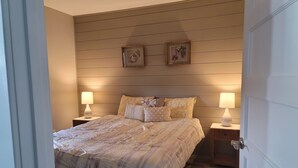 A neatly arranged bedroom with a bed, two bedside tables, and two wall-mounted lamps. - Cityline suite Three miles to PC, RIC, BROWN, JWU, &RISD (North Providence)