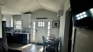 A kitchen with white cabinets, a dining table, and a door with a family sign. - Cityline suite Three miles to PC, RIC, BROWN, JWU, &RISD (North Providence)