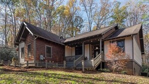 A two-story log cabin with a porch and a staircase leading to the upper floor. - Laurel Ridge, Privacy yet minutes from downtown, Dupont & Pisgah National Forest (Pisgah Forest)