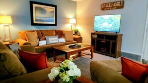 A cozy living room with a sofa, coffee table, and a flat-screen TV. - Tranquil 3 Bedroom, 2 Bath Home Near Scenic River Walk! (Baker City)