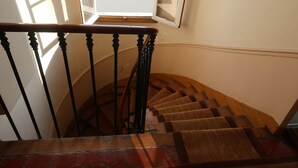 A wooden staircase with a handrail and a red brick wall at the bottom. - Studio 10 m2 - Coeur Batignolles - Near Champs Elysées & Montmartre (Paris)