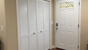 A hallway with a white door featuring a geometric stained glass design.