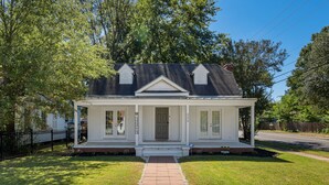 A single-story house with a front porch, a brick pathway leading to the entrance, and a well-maintained lawn.
